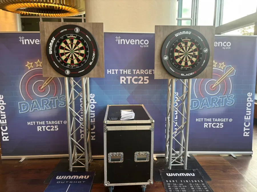 Branded dartboards on truss stands at a conference